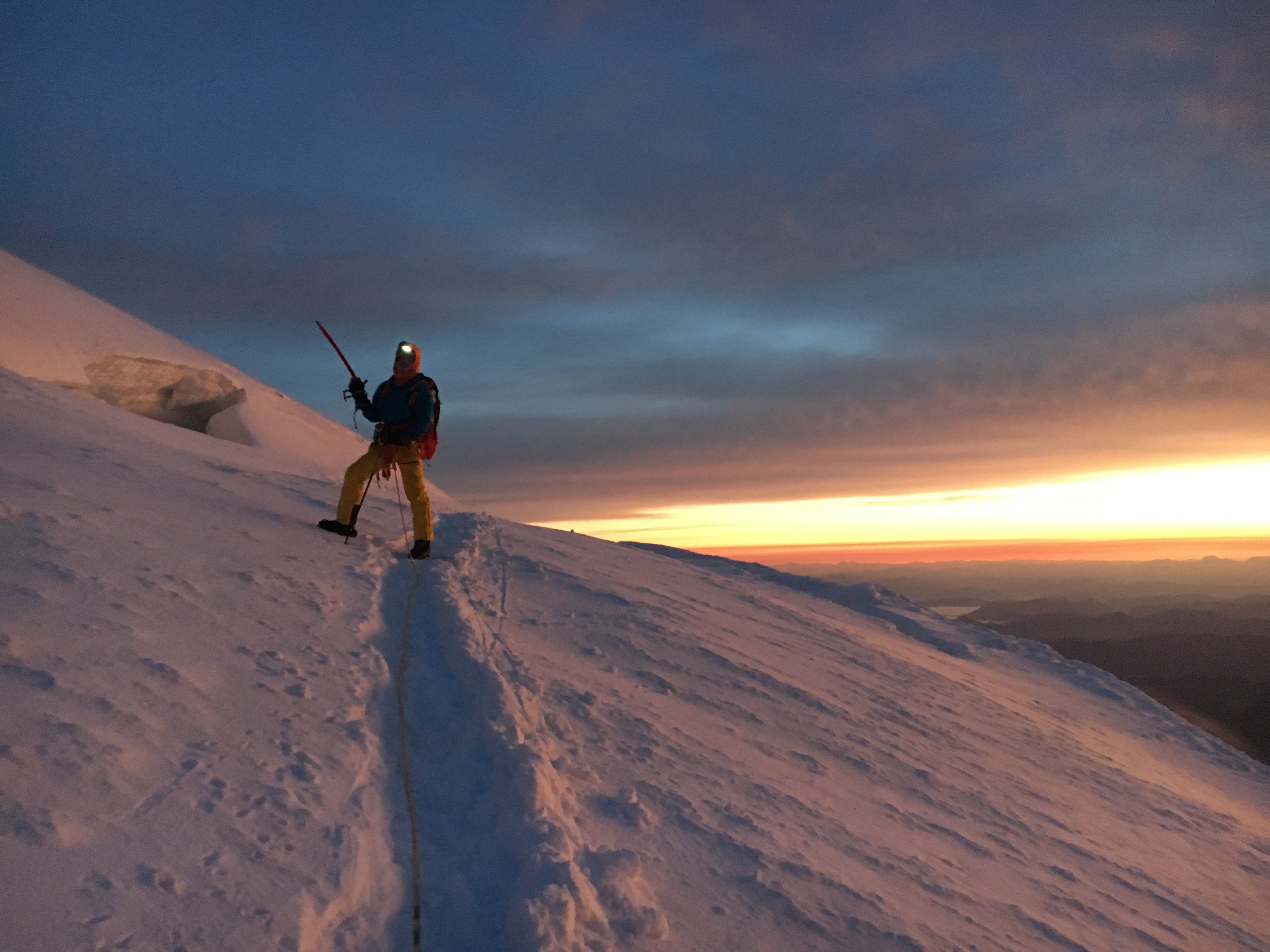 Ricky near the Mount Rainier Southeast Crater Rim, with the sun rising behind him.